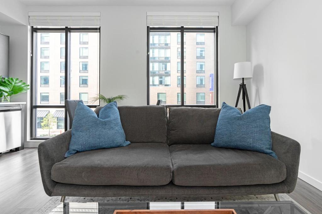 a living room with a brown couch with blue pillows at Business District Apartments by Barsala in Orlando