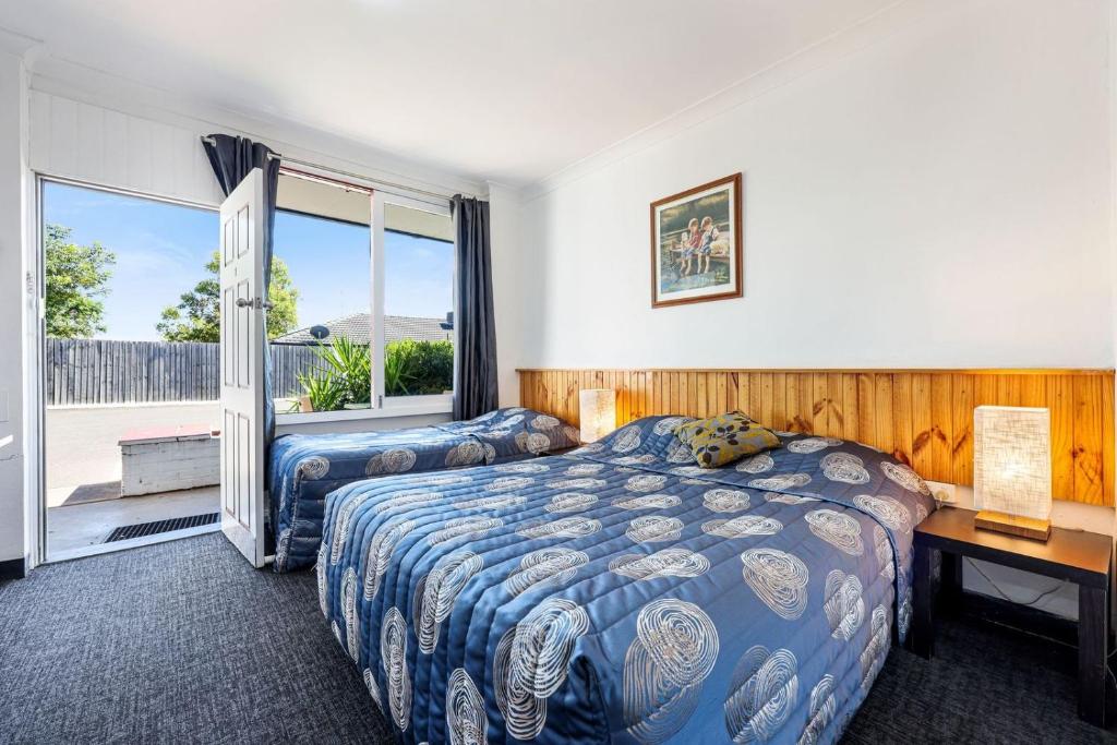 a bedroom with a bed and a desk and a window at Tamworth Budget Motel in Tamworth