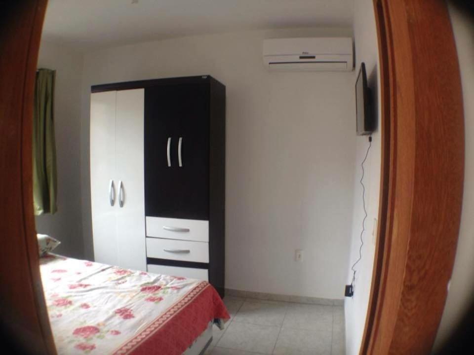 a bedroom with a bed and a black cabinet at Pousada Dunas Da Joaquina in Florianópolis