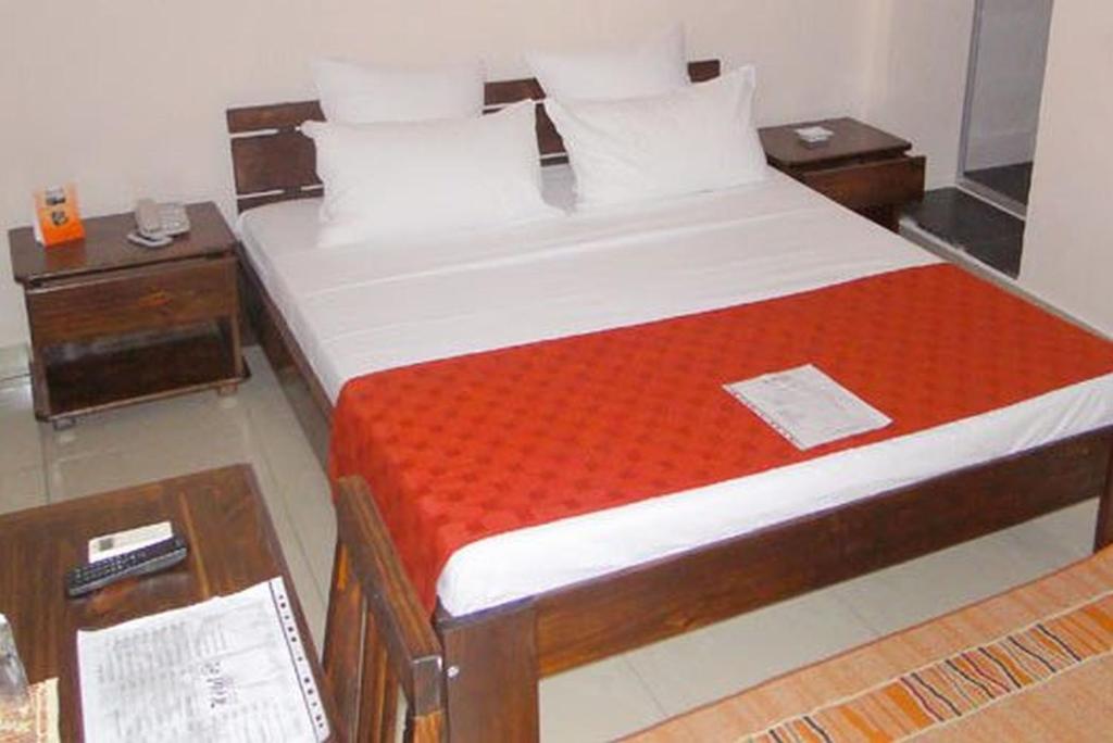 een slaapkamer met een bed met een rode deken bij Hotel H1 in Toamasina