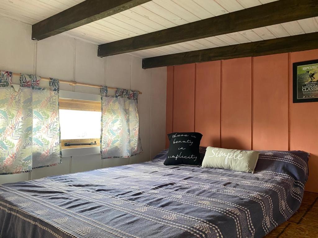 Una cama con dos almohadas encima en una habitación. en Tribu de Mar, en Mar del Plata