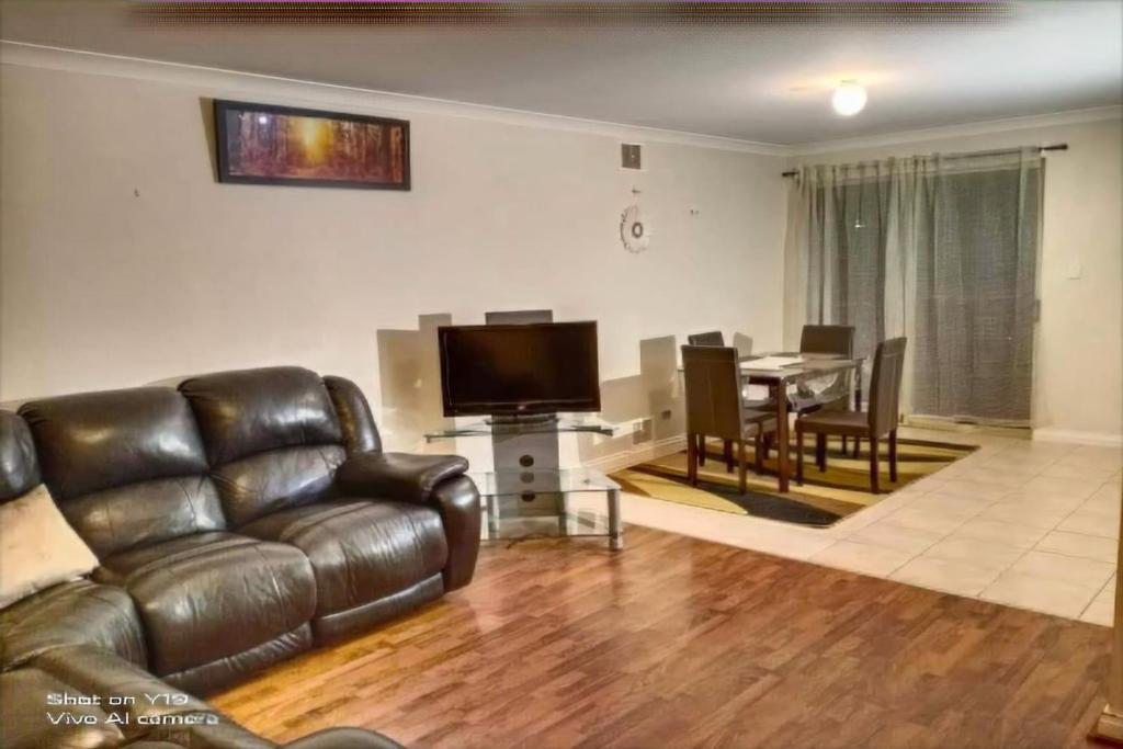a living room with a leather couch and a table at 2BR luxury house in Piccadilly in Kalgoorlie