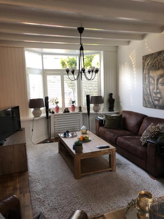 a living room with a couch and a coffee table at Lovely Tiny House Beverwijk/Amsterdam in Beverwijk