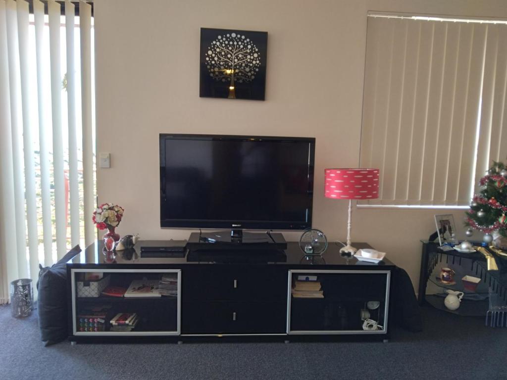 a flat screen tv sitting on top of a black entertainment center at Belle Vista in Wirrina Cove