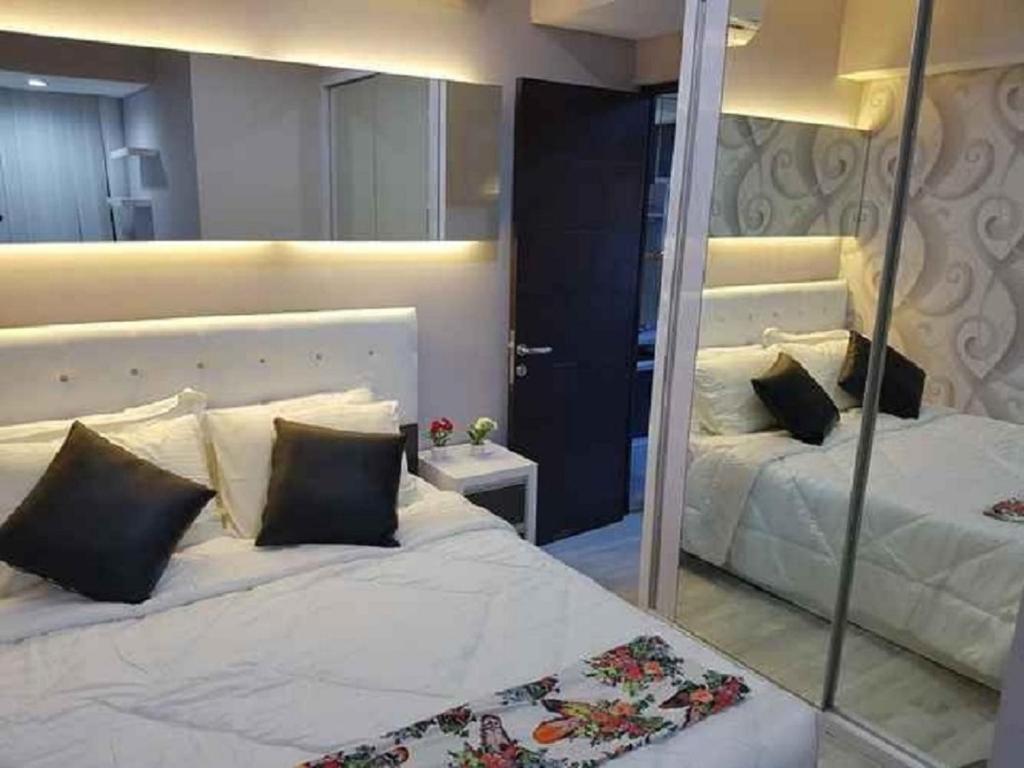 1 Schlafzimmer mit 2 Betten und einem Spiegel in der Unterkunft Aliston Papilio Apartment in Ngawinan