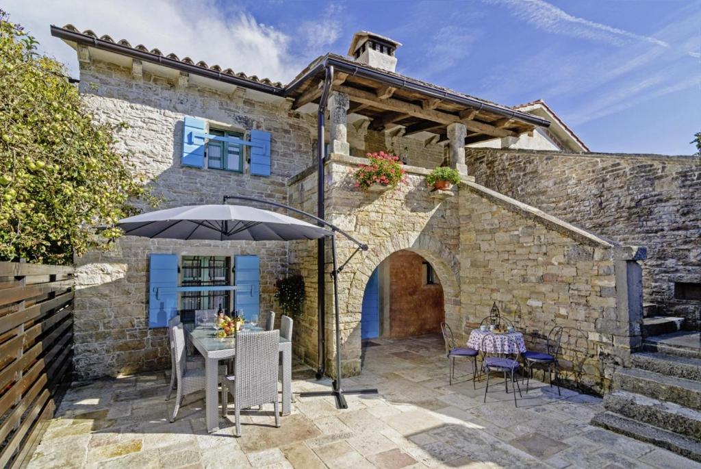 a patio with a table and an umbrella at Erisa in Trošti (Haus für 6 Personen) in Pazin