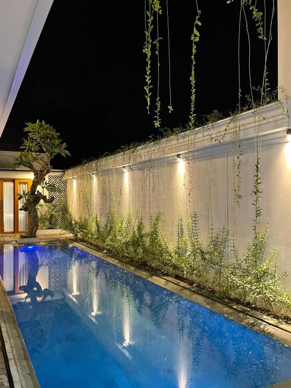 a swimming pool in a backyard at night at Marades Tropical Villa in Ngingas