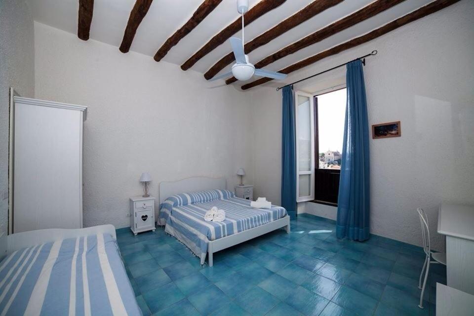 a bedroom with two beds and a ceiling fan at Guarinelli 88 in Gaeta