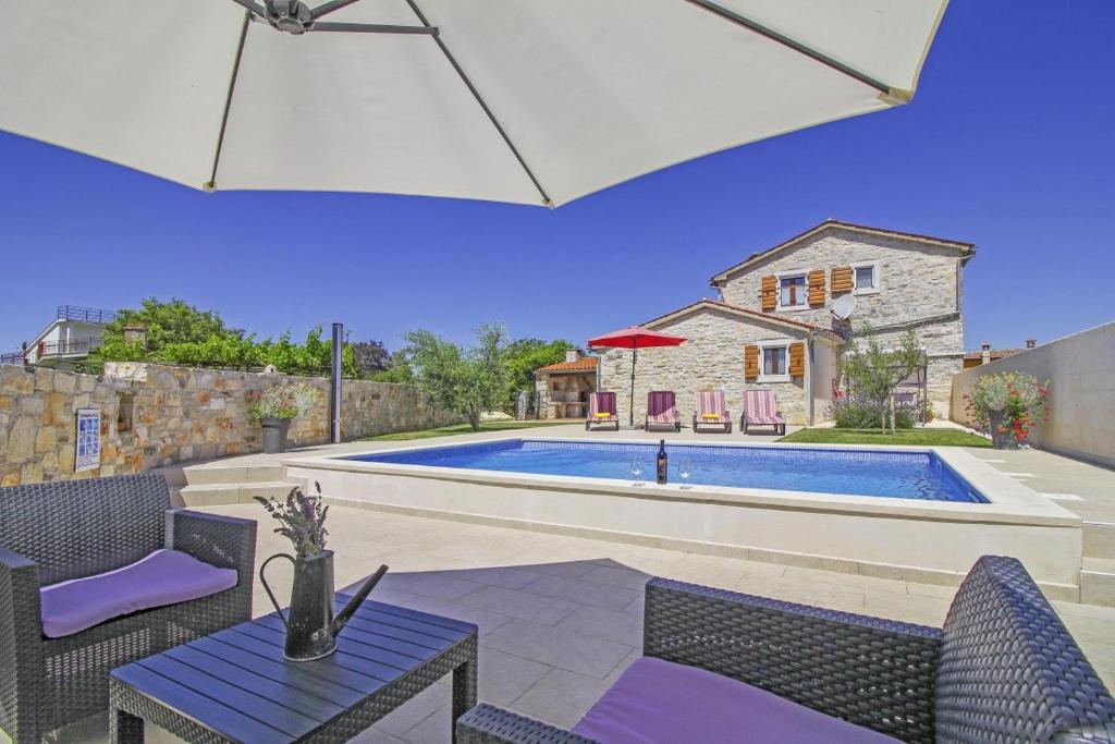 un patio con mesa y sillas y una piscina en Dolores in Cokuni (Haus für 4-5 Personen), en Krnica