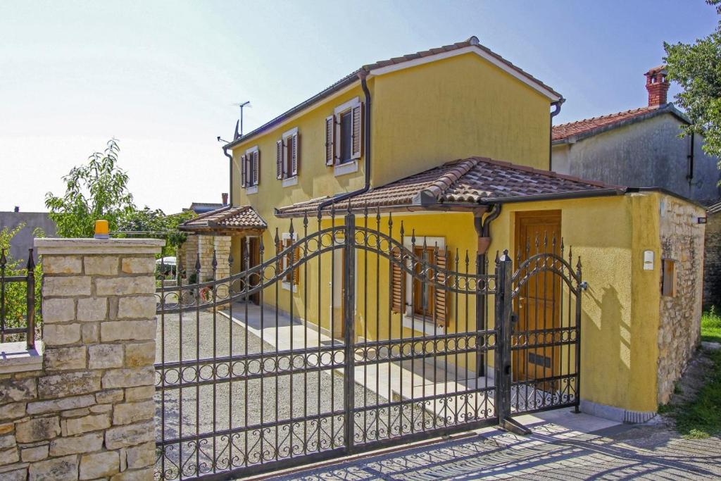 a yellow house with a gate and a fence at Alena in Debeljuhi (Haus für 4 Personen) in Žminj