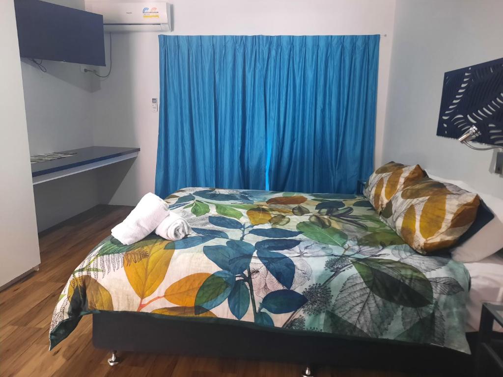 a bedroom with a bed and a blue curtain at Hay Point Hotel/Motel in Hay Point
