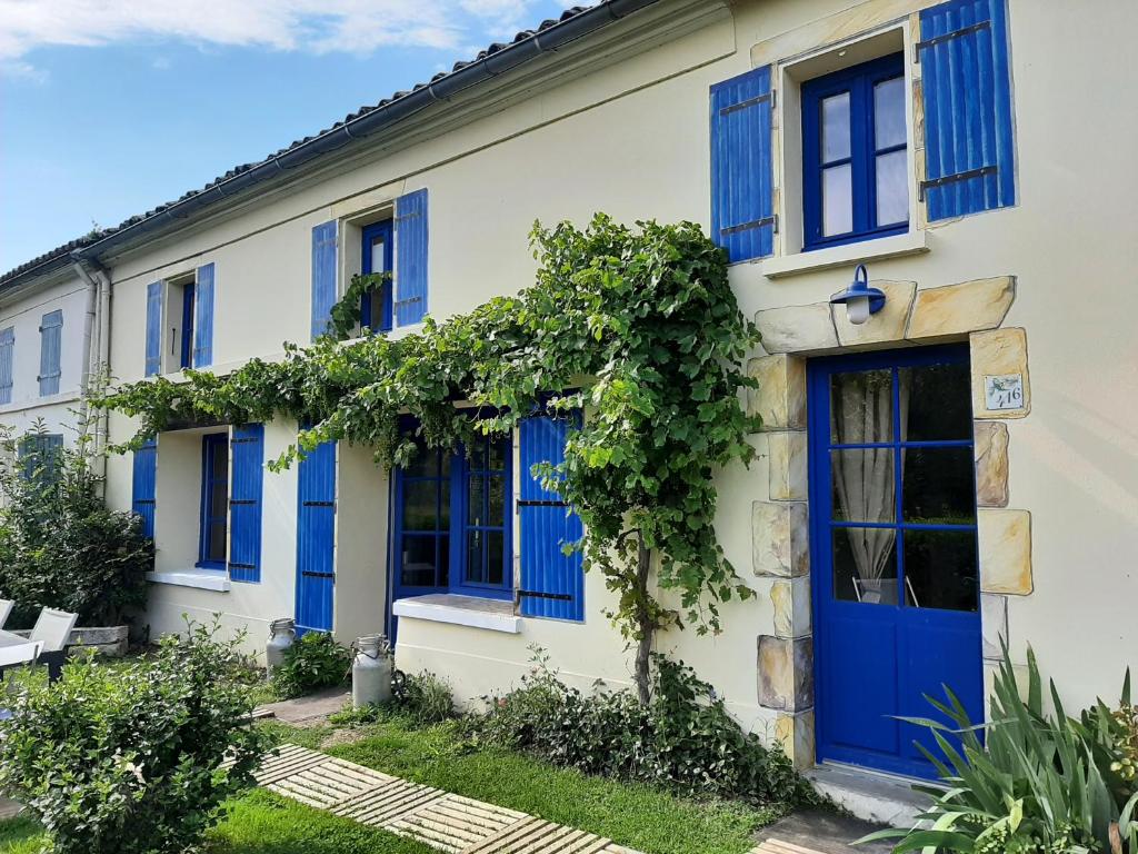a house with blue doors and ivy at Le logis du héron in Coulon