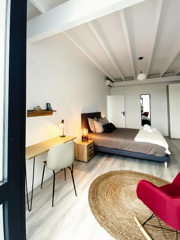 a bedroom with a bed and a desk at Sélina by Les Suites d&#39;Alfred in Saint-Denis