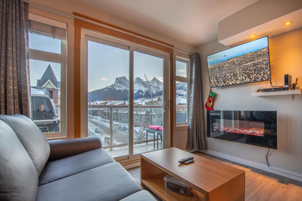 un soggiorno con divano e una grande finestra di Mountain View 2 Bedroom Condo - WT Top Floor-401 a Canmore