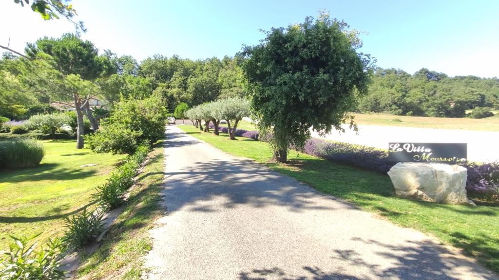 a gravel road with trees and a sign on the side at La Villa Moursoise 4 Etoiles in Mours-Saint-EusÃ¨be
