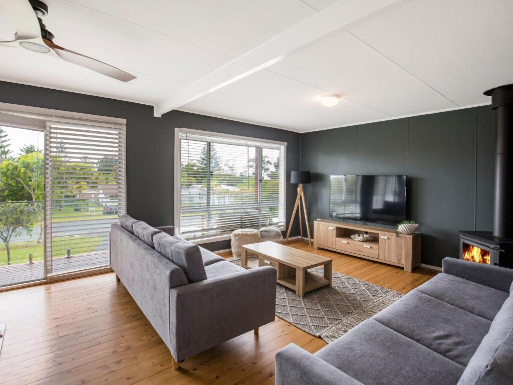 a living room with two couches and a tv at Sunfish Pet Friendly 4 Mins Walk to Beach in Culburra Beach
