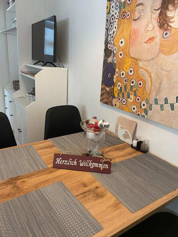 uma mesa de jantar com um quadro de uma mulher em Das Almsternderl - gemütliche Wohnung in Gosau em Gosau