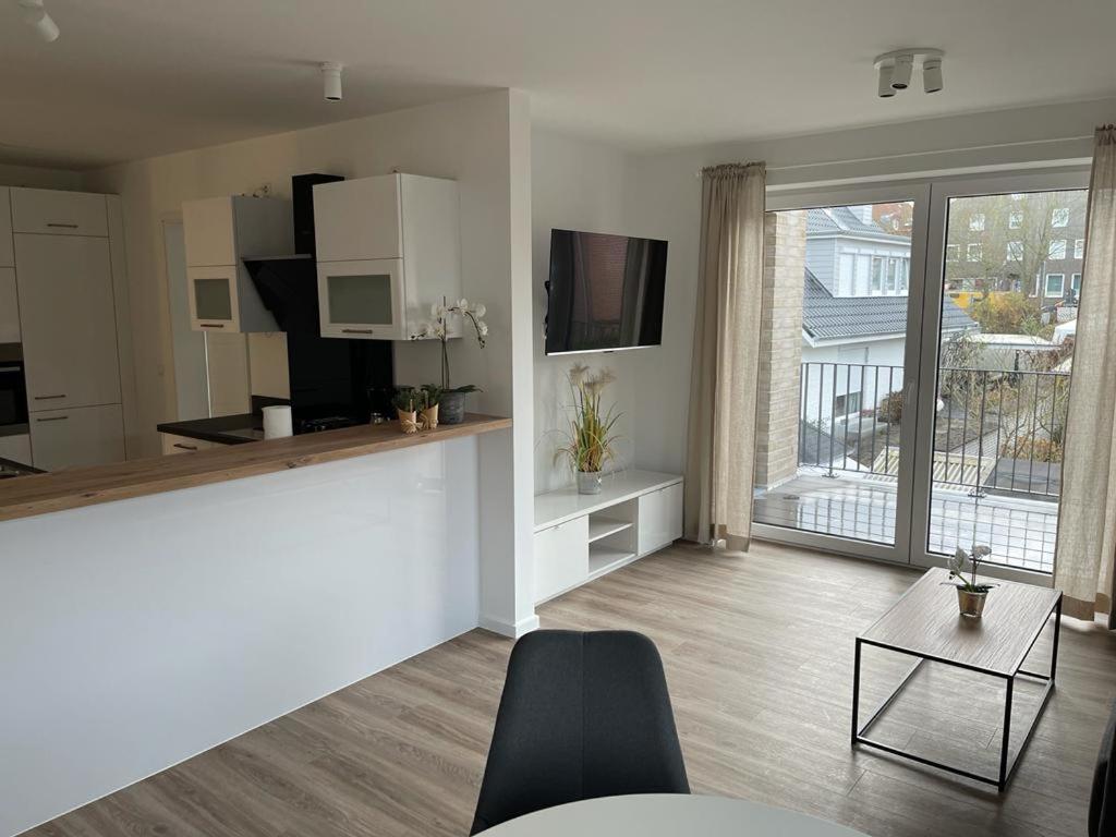 a living room with a kitchen and a large window at Appartments Eutiner Seepark in Eutin