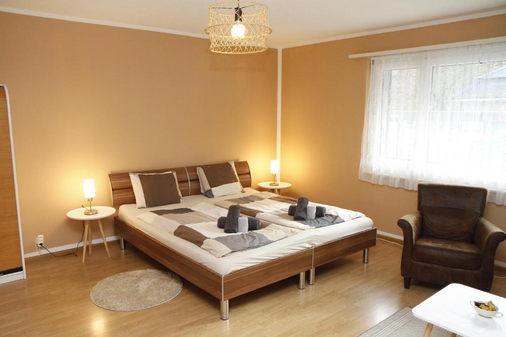 ein Schlafzimmer mit einem großen Bett und einem Stuhl in der Unterkunft Pension Breite in Basel