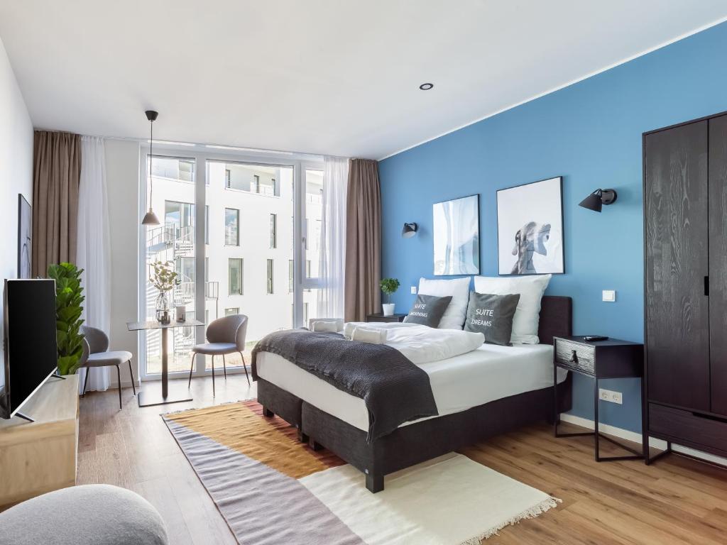 1 dormitorio con cama y pared azul en limehome Mönchengladbach Fliethstraße en Mönchengladbach