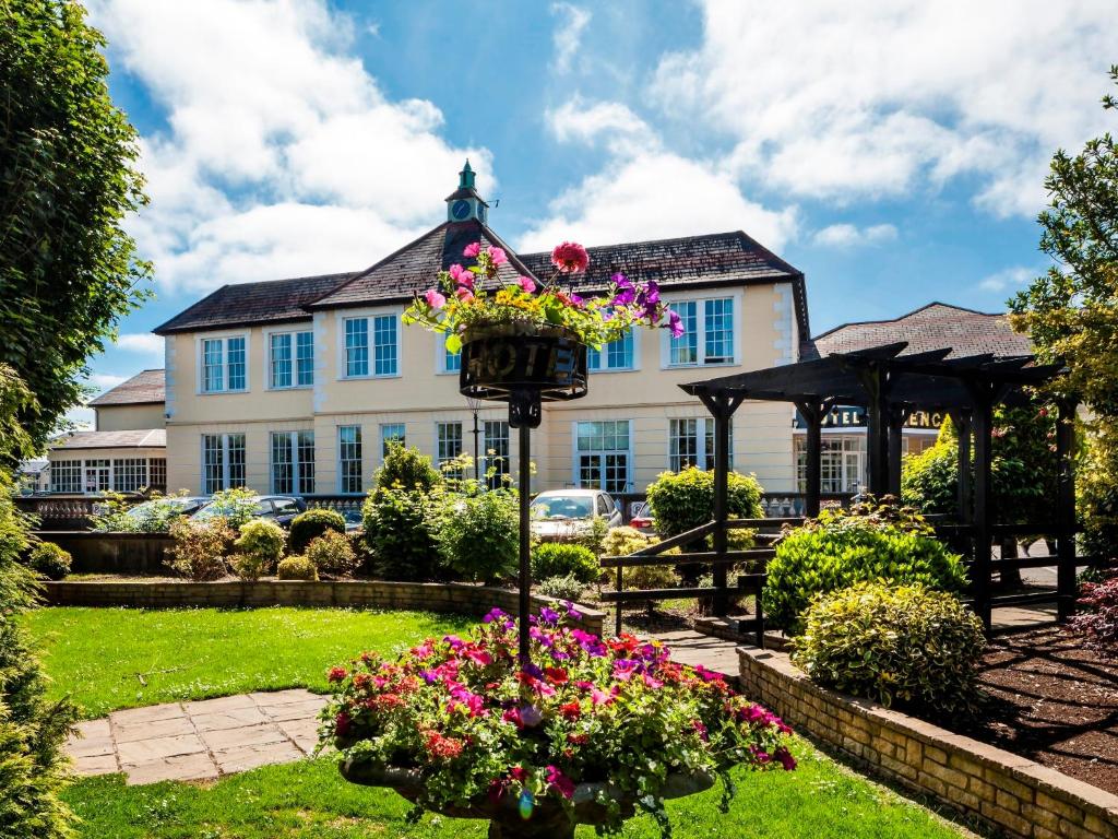 a garden with flowers in front of a building at The Glencarn Hotel in Castleblayney