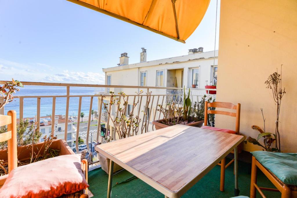 d'un balcon avec une table et des chaises en bois. dans l'établissement Le Béryl, à Nice