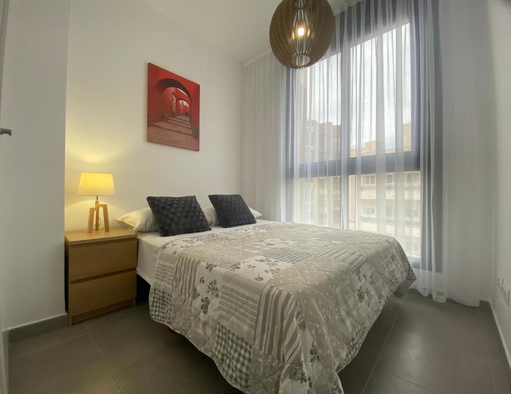 sypialnia z łóżkiem i dużym oknem w obiekcie Calpe Beach Sea View w mieście Calpe