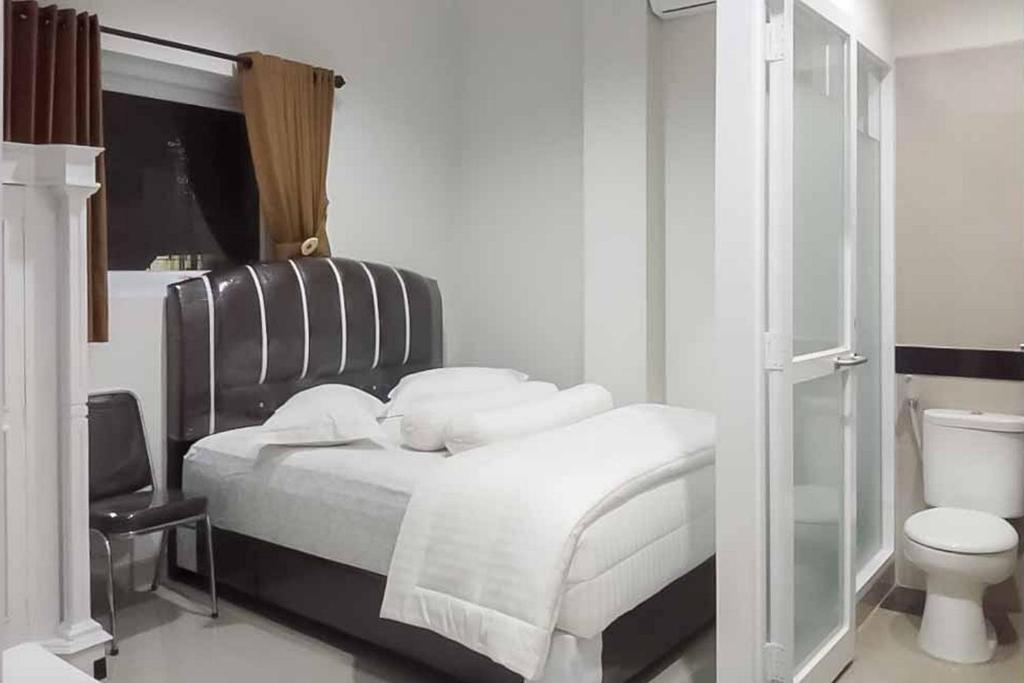 巨港的住宿－RedDoorz Plus near Palembang Airport 3，一间白色卧室,配有床和卫生间