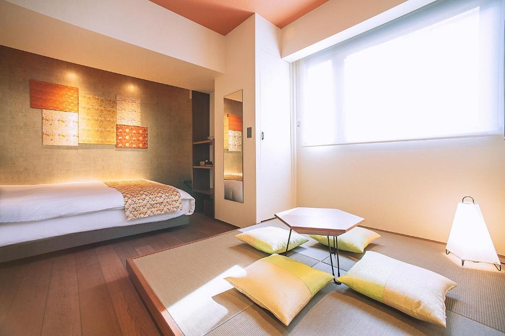 a bedroom with a bed and a table and a window at Asakusa Kaede 浅草楓 in Tokyo