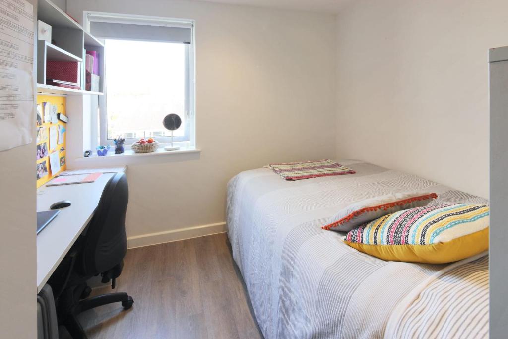 um quarto com uma cama, uma secretária e uma janela em For Students Only Private Bedrooms with Shared Kitchen at Riverside Way in Winchester em Winchester
