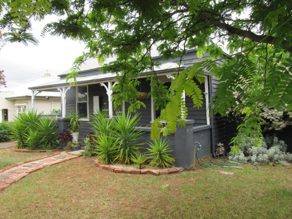 a house with plants in the front yard at Welcome Stranger Cottage in Maryborough