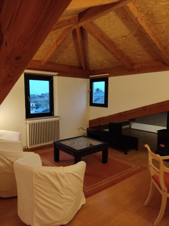 uma sala de estar com uma mesa e duas janelas em NAMOR - Atico Zen em Ribadeo