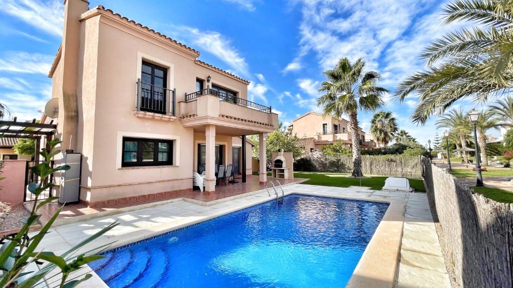 a villa with a swimming pool in front of a house at HL 020 Luxury 3 bedroom villa , high standard in Fuente Alamo