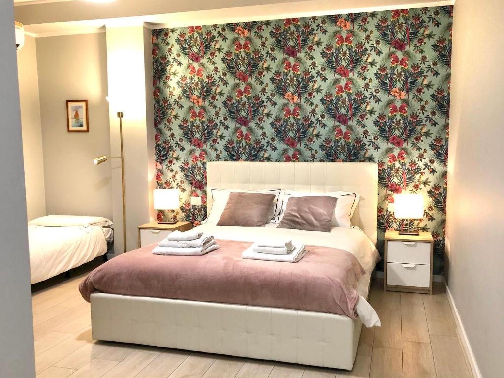 sypialnia z dużym łóżkiem i tapetą w kwiaty w obiekcie Sunny Beach Bari w mieście Bari