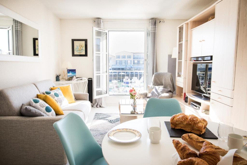 a living room with a couch and a table at Escale à deux au coeur de l'île de Ré - La Rétaise in Saint-Martin-de-Ré