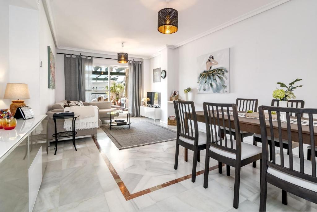 comedor y sala de estar con mesa y sillas en LCR4- Large 3 bed apt close to beaches, en Marbella