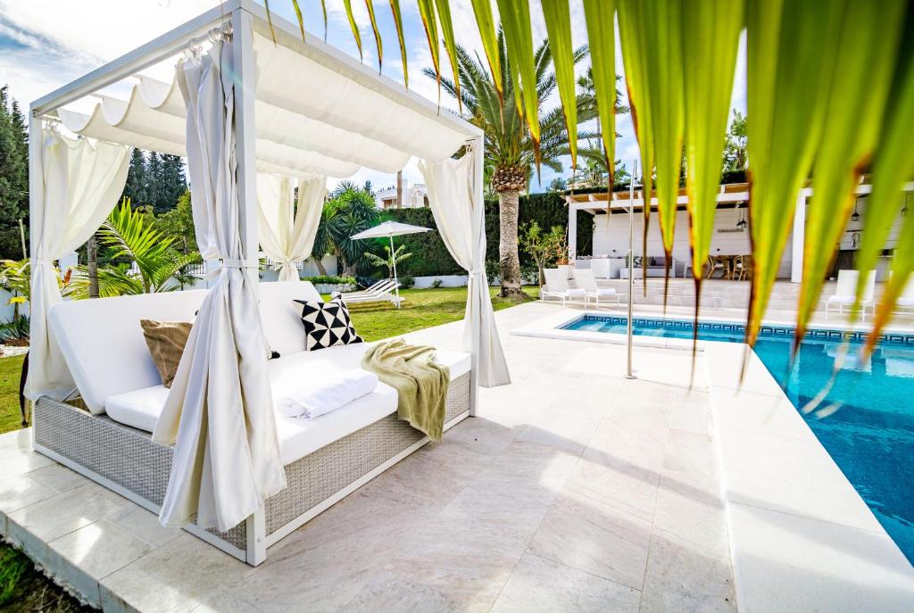 マルベーリャにあるVM-Lyxury 4 bedroom villa with private poolのプールサイドのベッドルーム1室(天蓋付きベッド1台付)