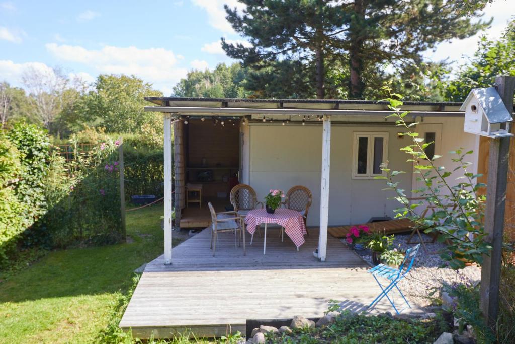 een tafel en stoelen op een veranda van een schuur bij Bergliot Bed & Breakfast in Hundested