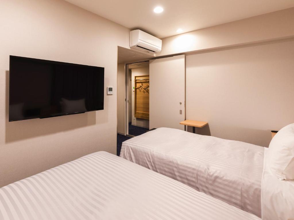 Postel nebo postele na pokoji v ubytování Sotetsu Fresa Inn Nagoya-Shinkansenguchi