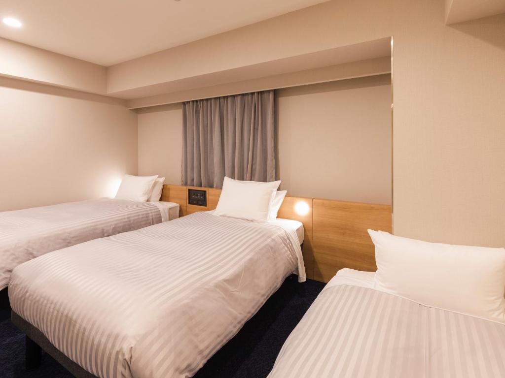 Postel nebo postele na pokoji v ubytování Sotetsu Fresa Inn Nagoya-Shinkansenguchi