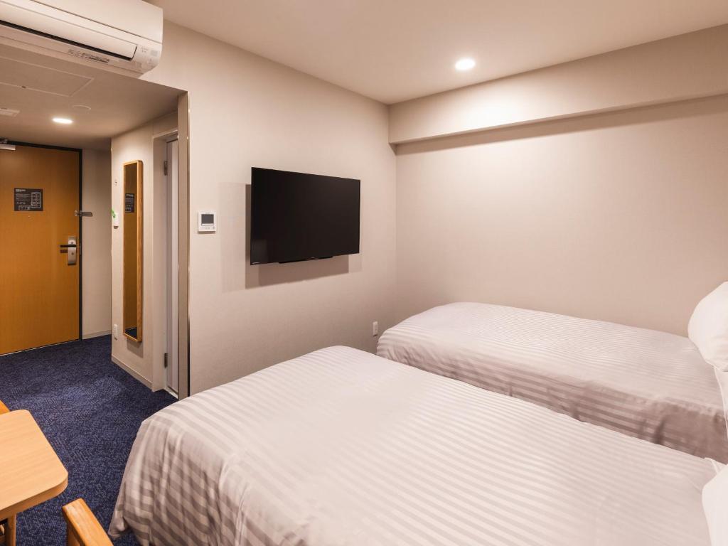 Postel nebo postele na pokoji v ubytování Sotetsu Fresa Inn Nagoya-Shinkansenguchi