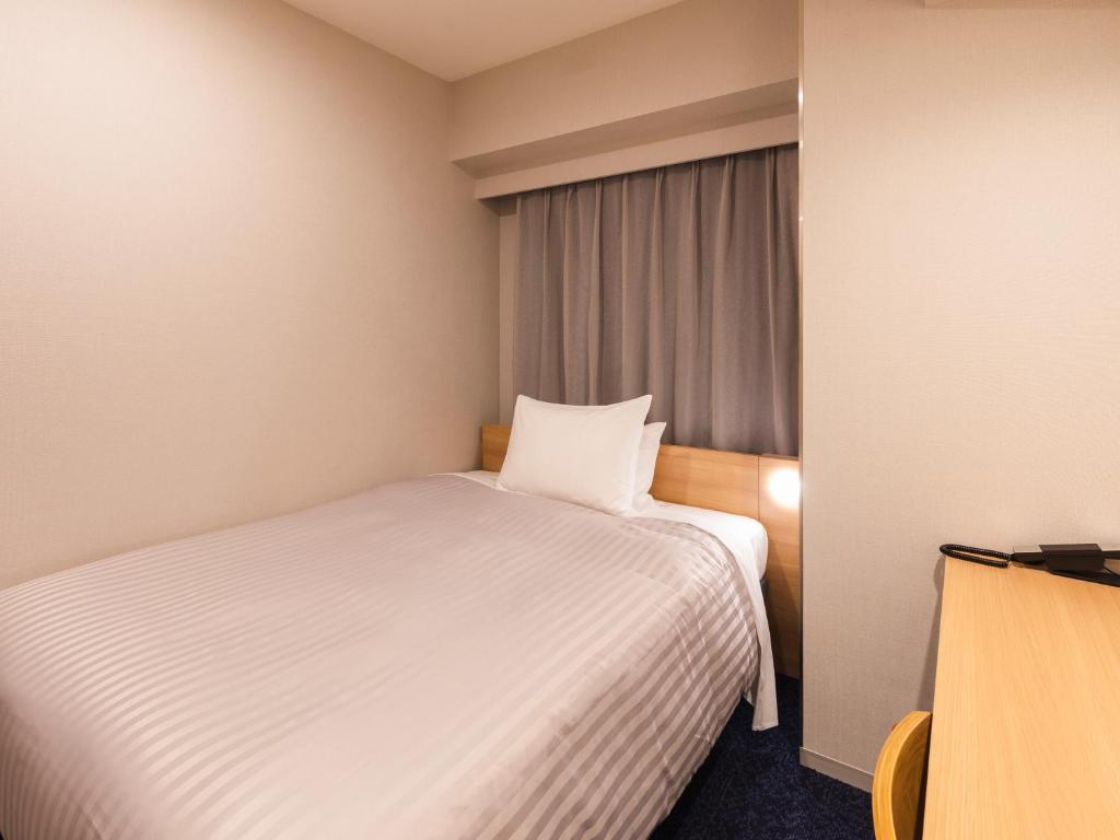 Postel nebo postele na pokoji v ubytování Sotetsu Fresa Inn Nagoya-Shinkansenguchi