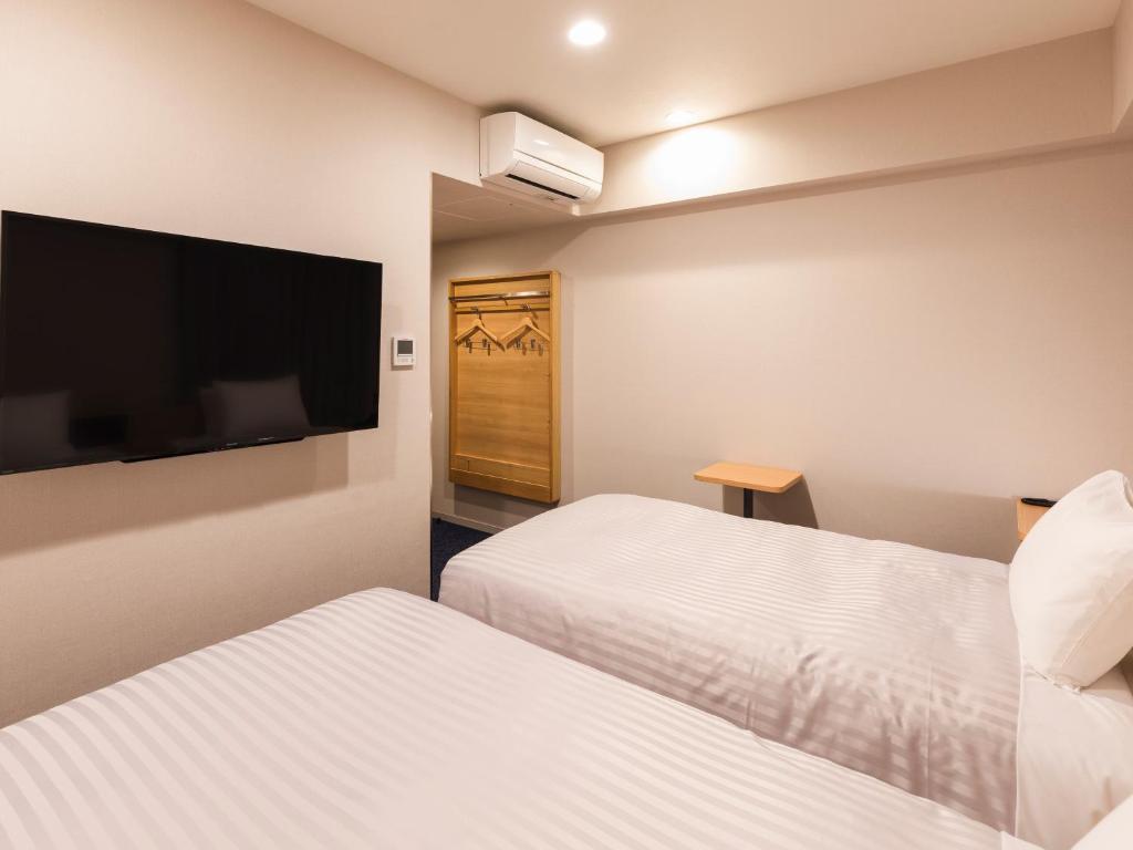 Postel nebo postele na pokoji v ubytování Sotetsu Fresa Inn Nagoya-Shinkansenguchi