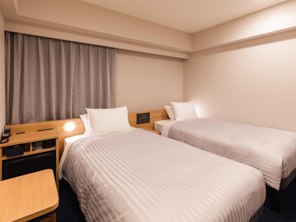 Postel nebo postele na pokoji v ubytování Sotetsu Fresa Inn Nagoya-Shinkansenguchi