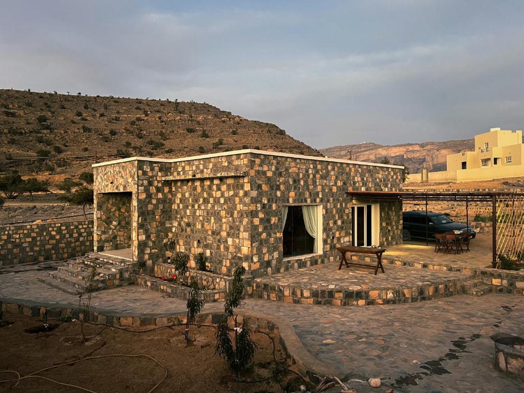 ein Steingebäude mit einer Bank davor in der Unterkunft Sab Bani Khamis House in Sa‘ab Banī Khamīs