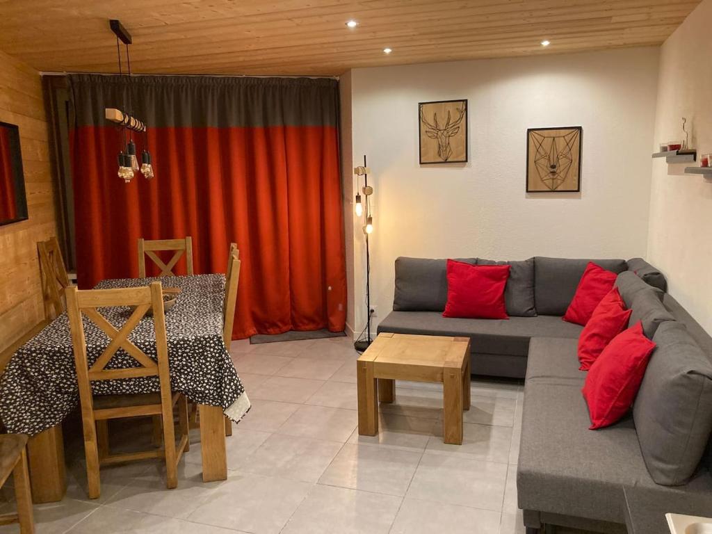 a living room with a gray couch and red pillows at Great 8-pax ski-in ski-out apartment in Tignes Val Claret in Tignes