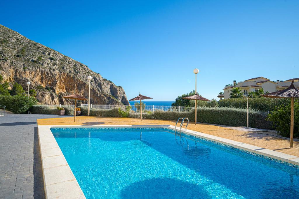 a blue swimming pool with a view of the ocean at Casa Vistamar in Altea