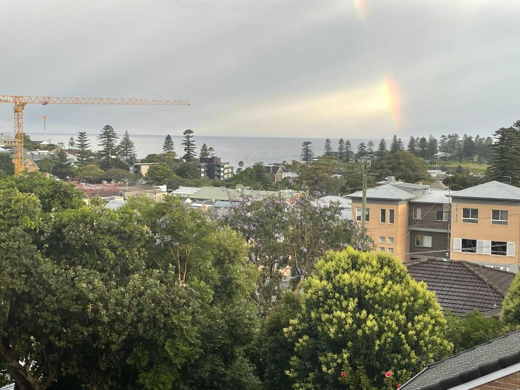 a rainbow in the sky over a city with trees at Kiama Palms on Terralong in Kiama