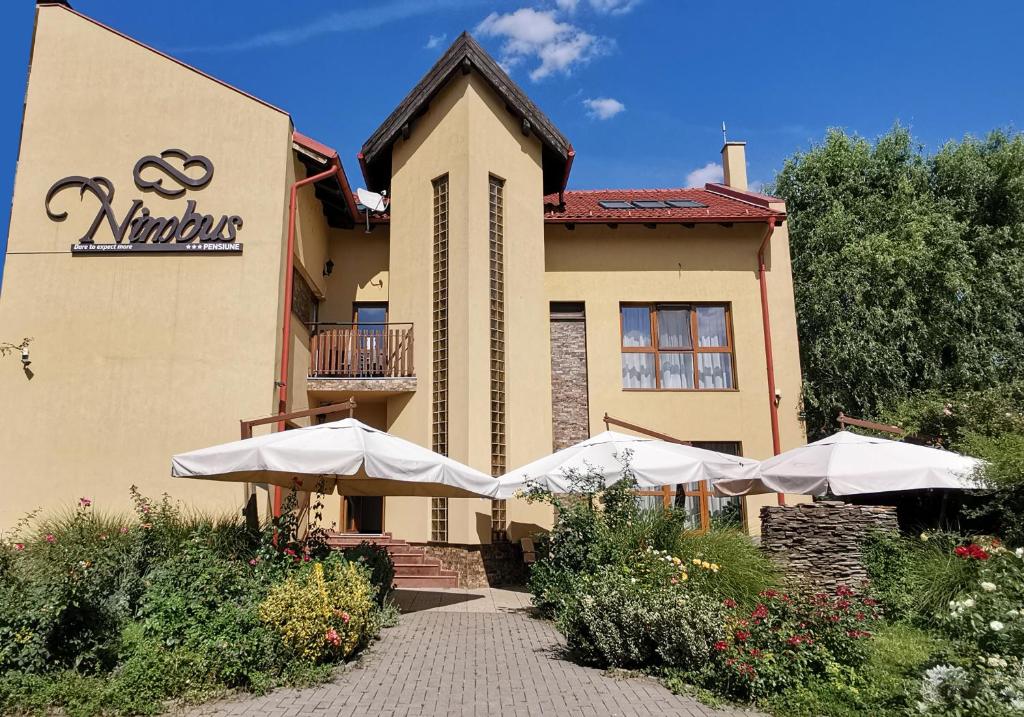 un restaurante con sombrillas frente a un edificio en Pensiunea Nimbus en Arad
