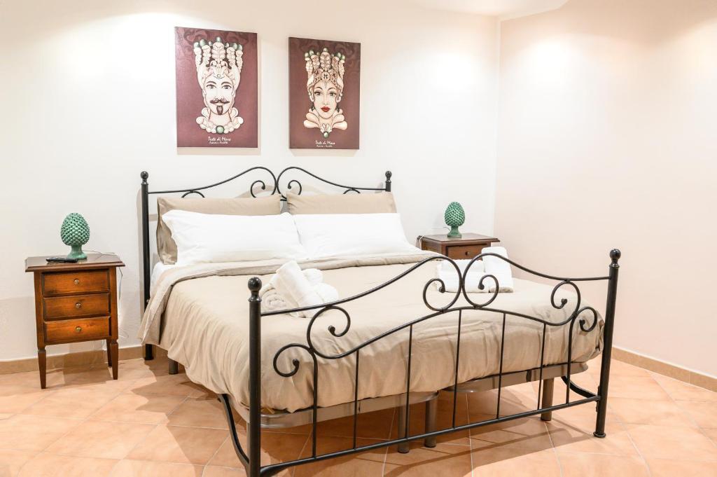 een slaapkamer met een bed en twee schilderijen aan de muur bij Daria’s home apartament in Palermo
